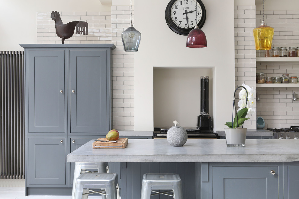 This is an example of an eclectic single-wall kitchen in London with grey cabinets, concrete worktops, white splashback, metro tiled splashback and an island.