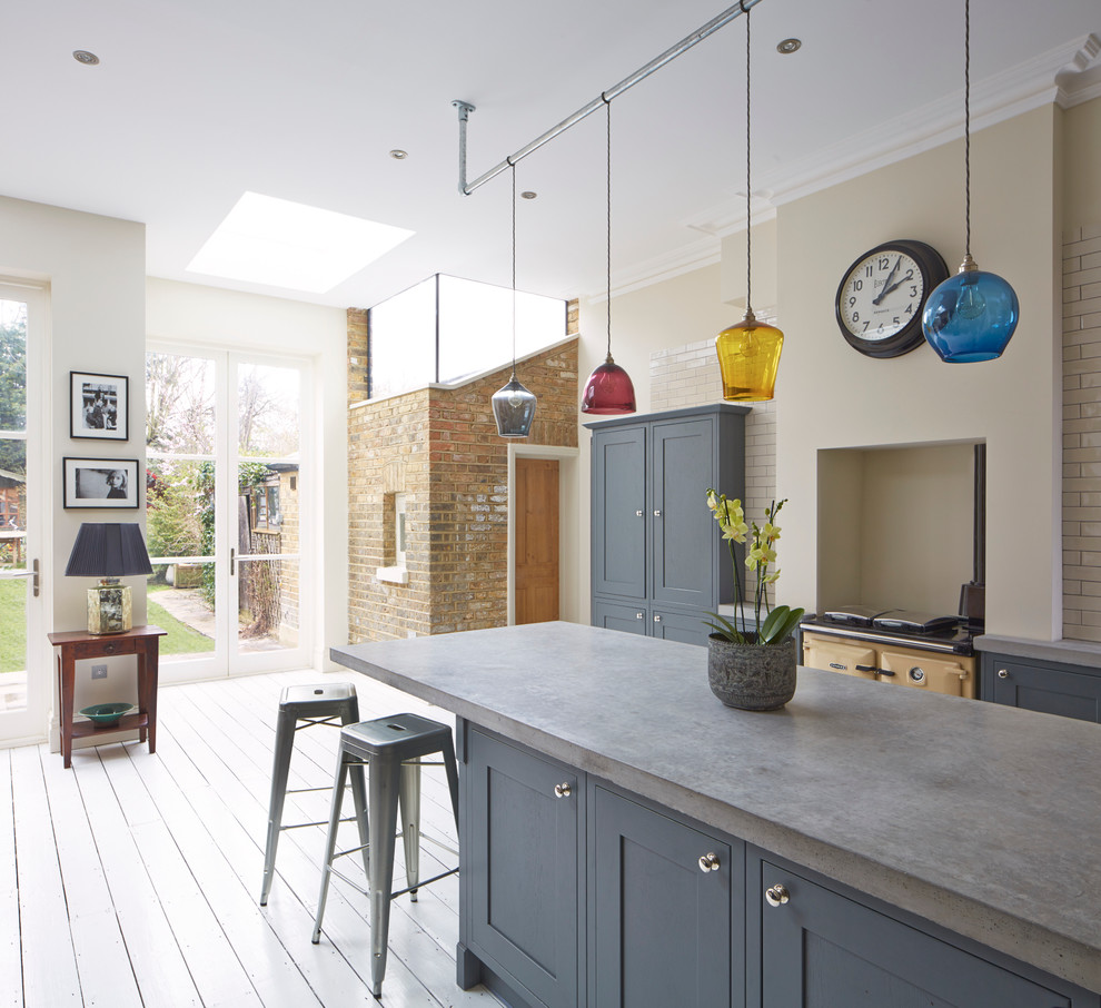 Inspiration for an industrial grey and cream kitchen in London with recessed-panel cabinets, blue cabinets, concrete worktops, metro tiled splashback and coloured appliances.