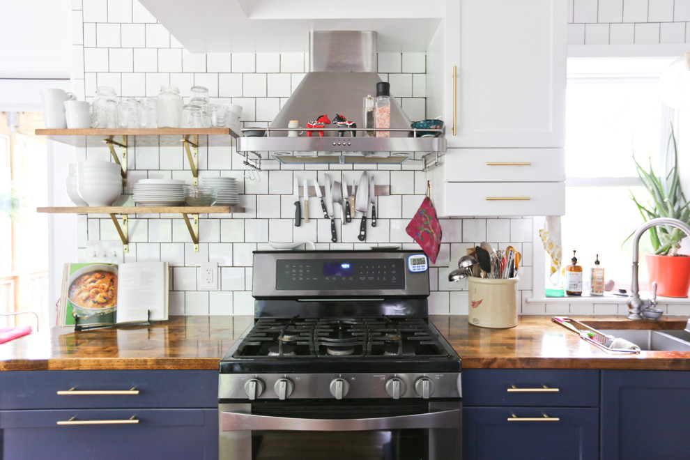 Esempio di una piccola cucina moderna con ante con riquadro incassato, ante blu, top in legno, paraspruzzi bianco, pavimento in legno massello medio e top marrone
