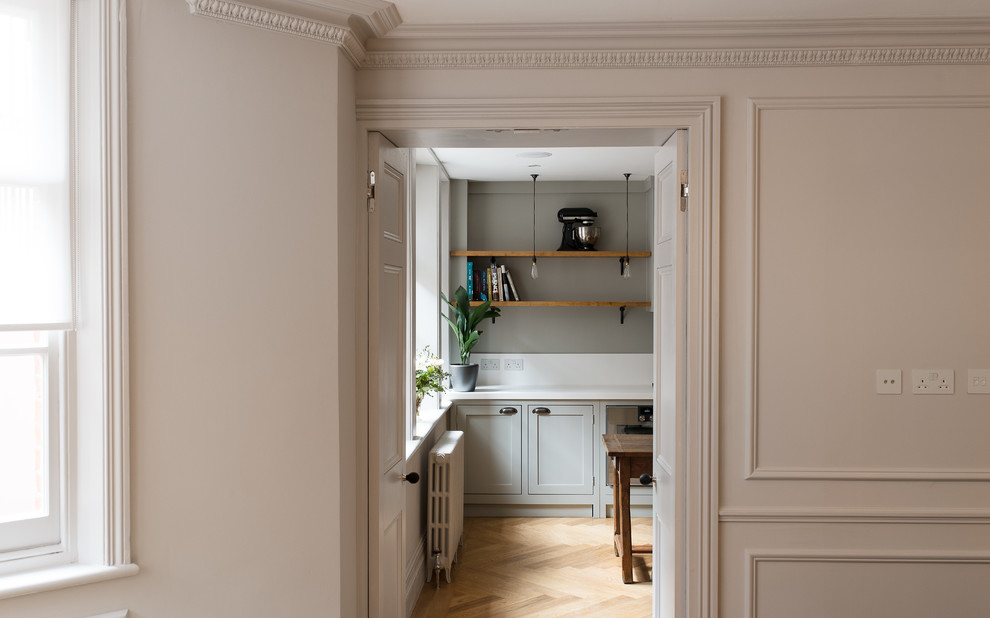 Immagine di una piccola cucina classica chiusa con ante in stile shaker, ante in legno chiaro e pavimento in legno massello medio