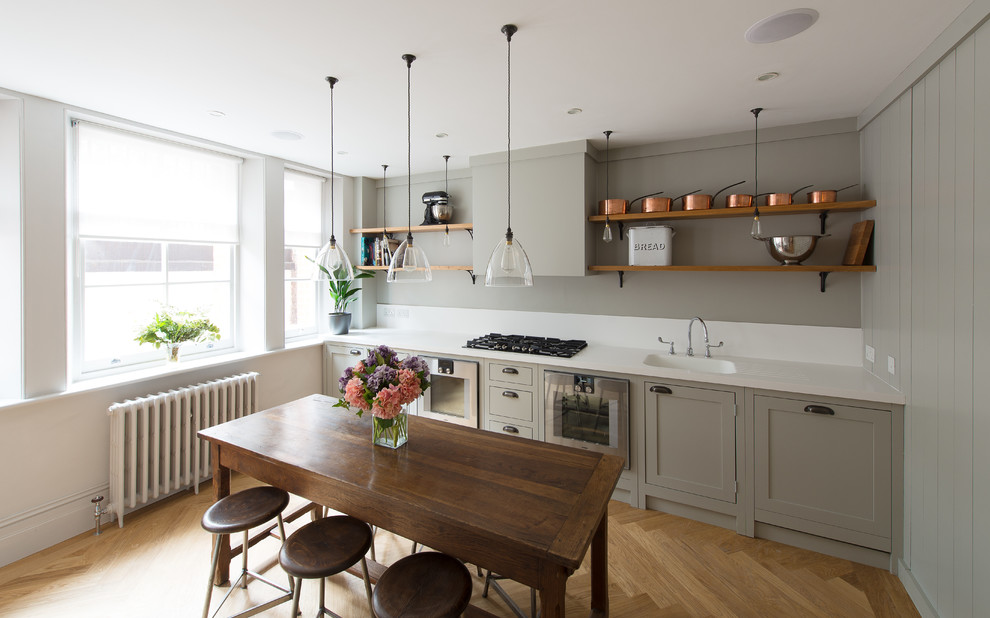 Inspiration for a small classic enclosed kitchen in London with shaker cabinets, light wood cabinets and medium hardwood flooring.