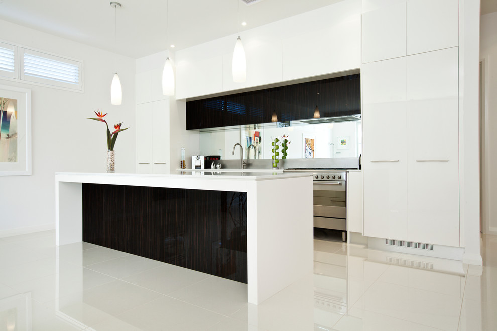 Photo of a medium sized contemporary galley open plan kitchen in Adelaide with a submerged sink, flat-panel cabinets, white cabinets, engineered stone countertops, mirror splashback, stainless steel appliances, porcelain flooring and an island.