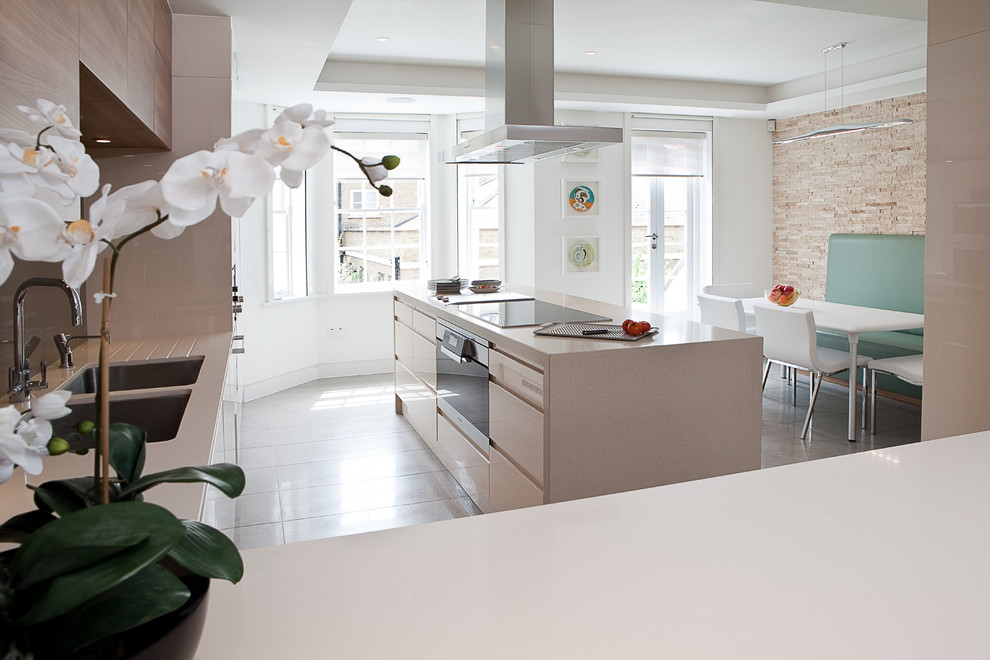 Moderne Wohnküche mit Unterbauwaschbecken, flächenbündigen Schrankfronten und beigen Schränken in London