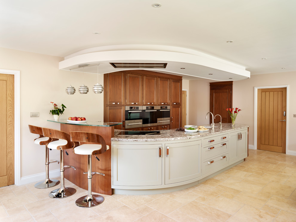 Modern inredning av ett stort kök, med skåp i shakerstil, granitbänkskiva, travertin golv och en köksö