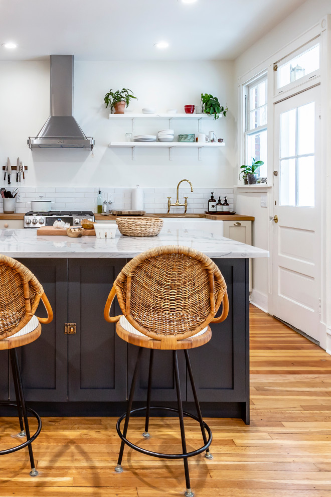Eat-in kitchen - large country single-wall medium tone wood floor eat-in kitchen idea in Richmond with a farmhouse sink, shaker cabinets, beige cabinets, wood countertops, white backsplash, subway tile backsplash, stainless steel appliances and an island