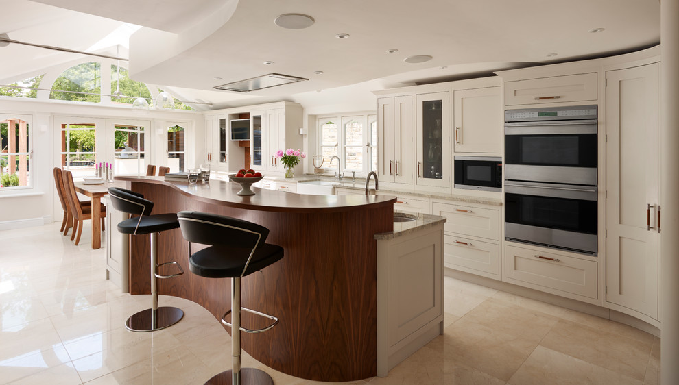 ロンドンにある高級な広いコンテンポラリースタイルのおしゃれなキッチン (グレーのキャビネット、御影石カウンター、シルバーの調理設備) の写真