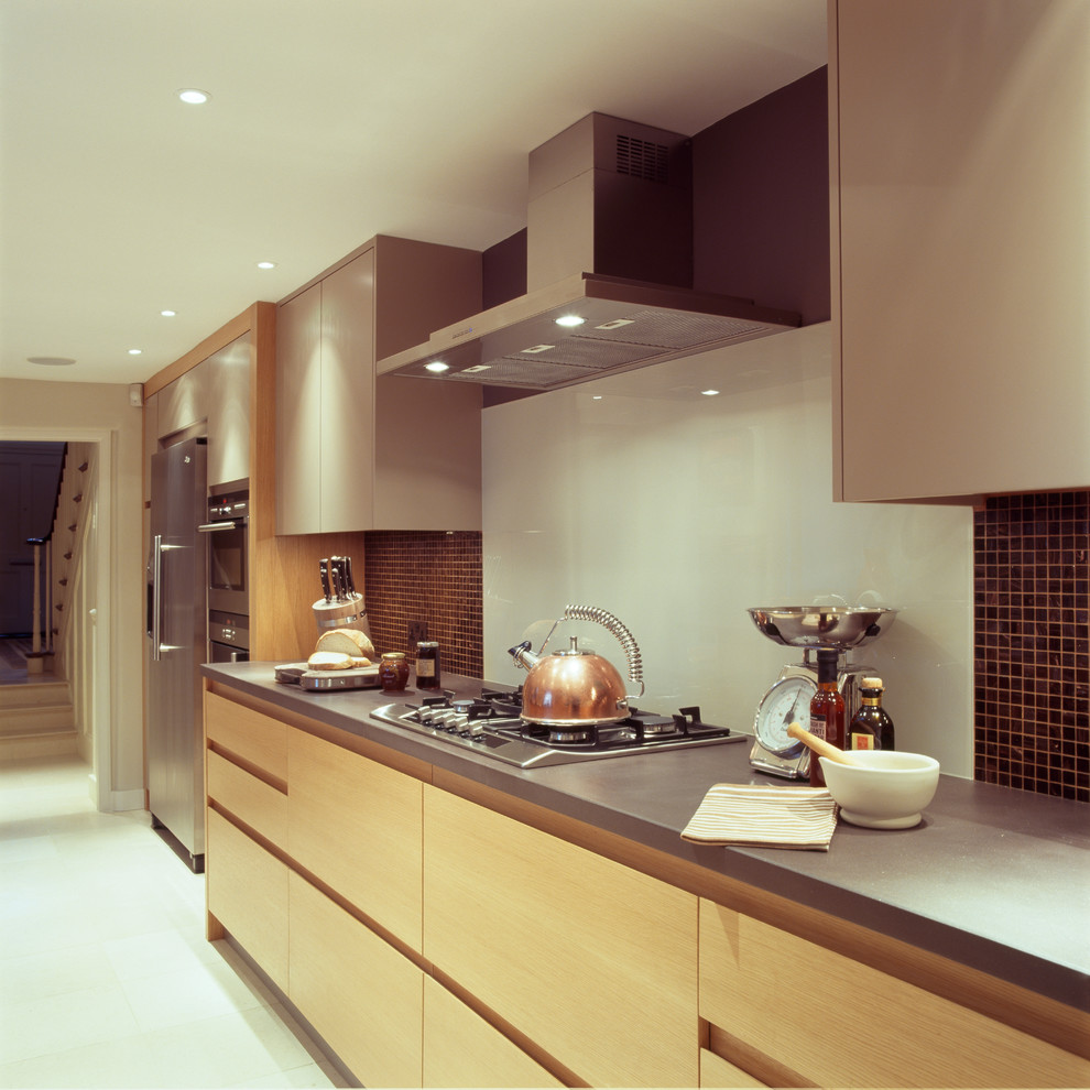 Large trendy kitchen photo in London with flat-panel cabinets, light wood cabinets, white backsplash and stainless steel appliances
