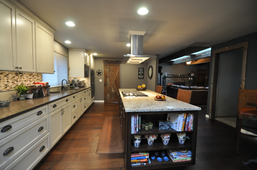 Bild på ett stort rustikt linjärt kök och matrum, med en rustik diskho, luckor med infälld panel, vita skåp, bänkskiva i kvarts, beige stänkskydd, stänkskydd i mosaik, rostfria vitvaror, mörkt trägolv och en köksö
