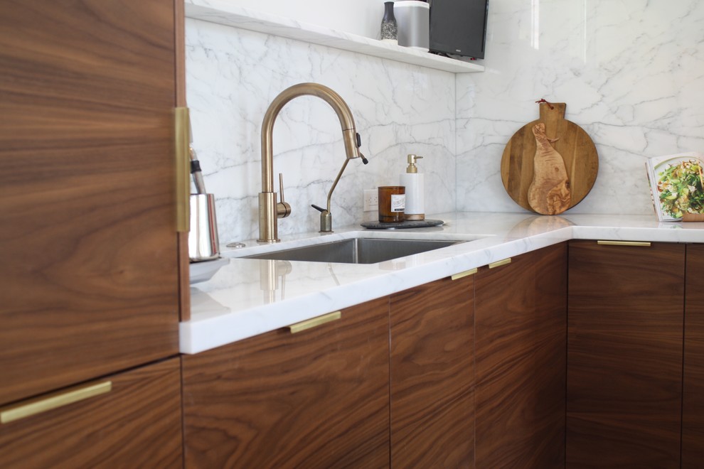 Inspiration for a contemporary l-shaped light wood floor open concept kitchen remodel in Los Angeles with a single-bowl sink, flat-panel cabinets, medium tone wood cabinets, marble countertops, white backsplash, stone slab backsplash, stainless steel appliances and an island