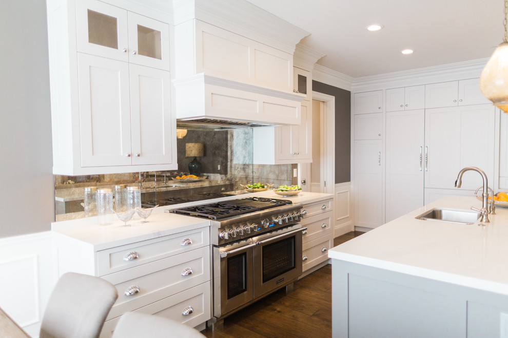 This is an example of a large classic l-shaped open plan kitchen in San Francisco with a submerged sink, shaker cabinets, grey cabinets, composite countertops, mirror splashback, stainless steel appliances, medium hardwood flooring and an island.