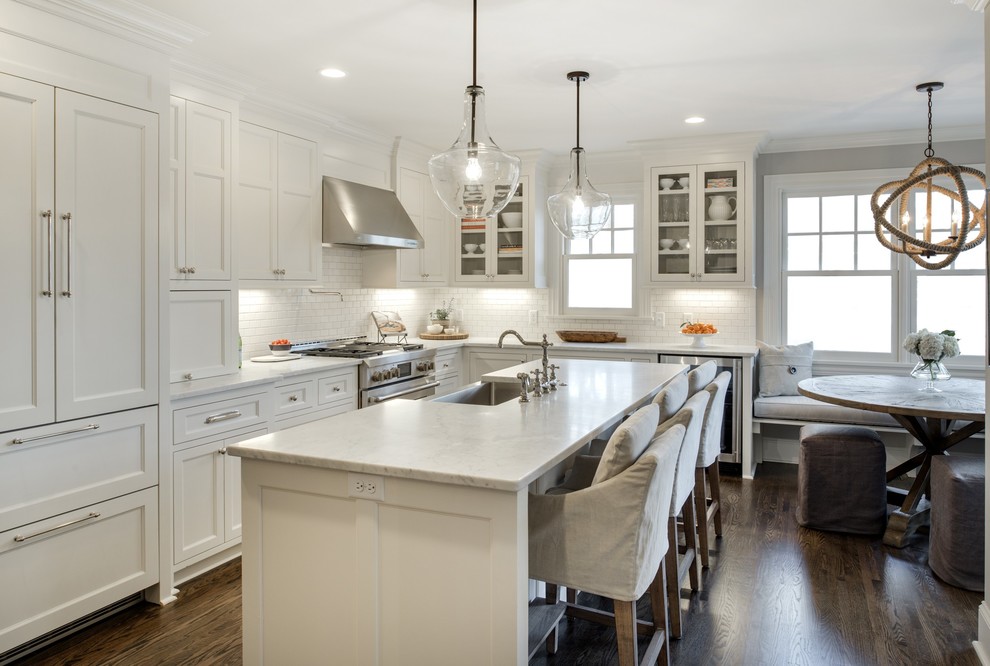Exempel på ett avskilt, stort klassiskt l-kök, med en undermonterad diskho, skåp i shakerstil, vita skåp, marmorbänkskiva, vitt stänkskydd, stänkskydd i stenkakel, rostfria vitvaror, mörkt trägolv och en köksö