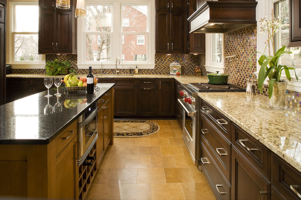 Exemple d'une cuisine chic en bois foncé avec une crédence en mosaïque, un électroménager en acier inoxydable, une crédence multicolore et un placard avec porte à panneau encastré.