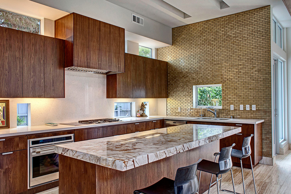 Moderne Küche mit flächenbündigen Schrankfronten, hellbraunen Holzschränken, Küchenrückwand in Beige und Küchengeräten aus Edelstahl in Los Angeles
