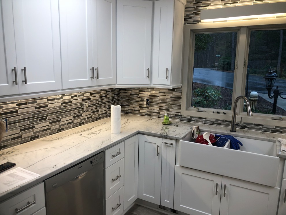 Bild på ett mellanstort funkis vit vitt kök, med en rustik diskho, skåp i shakerstil, vita skåp, bänkskiva i kvartsit, grått stänkskydd, stänkskydd i mosaik, rostfria vitvaror, ljust trägolv och grått golv