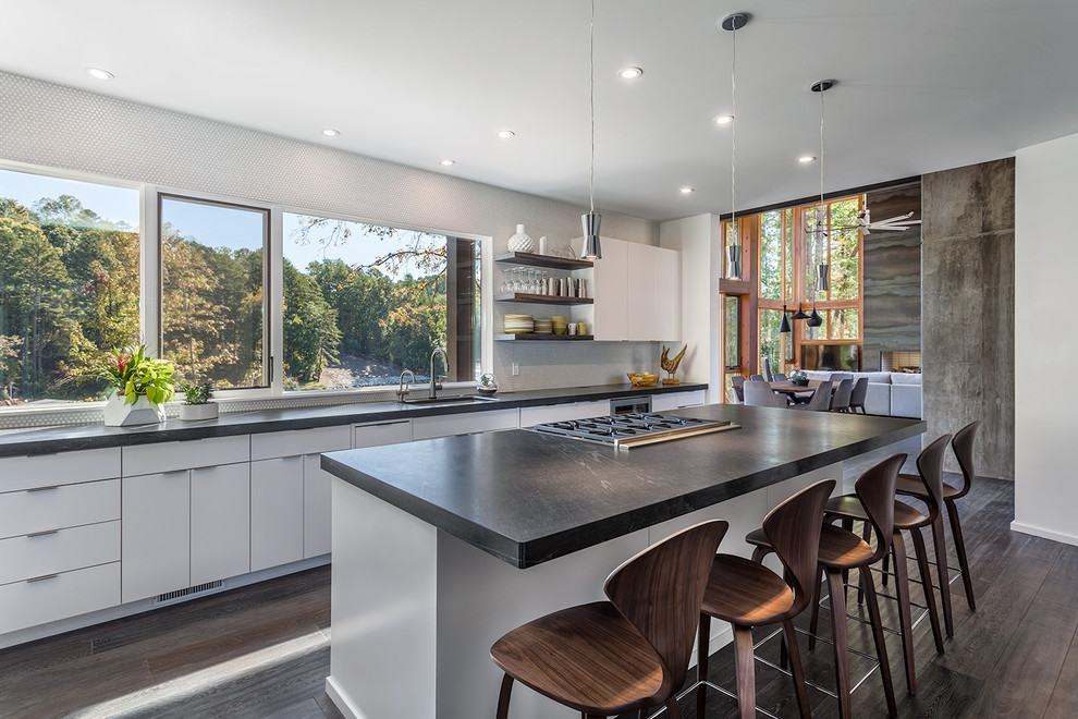 Contemporary kitchen in Other with a submerged sink, flat-panel cabinets, white cabinets, window splashback, dark hardwood flooring, an island, brown floors and soapstone worktops.