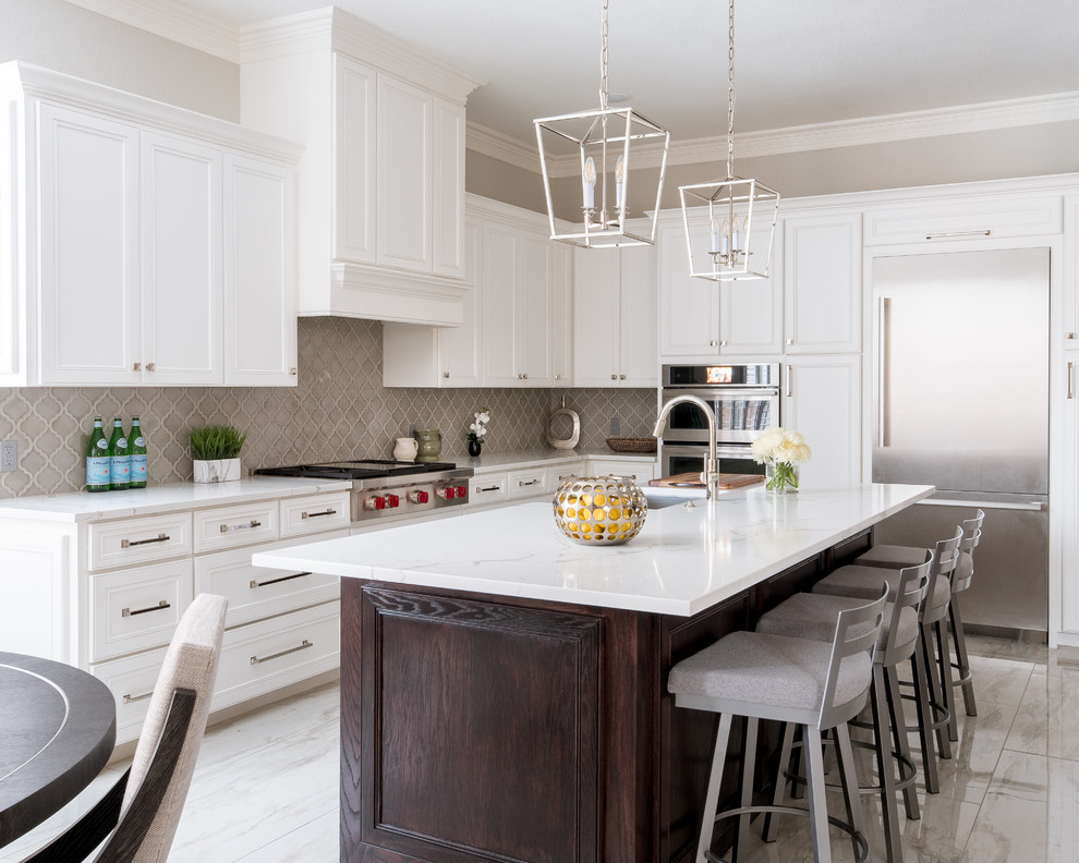 Eat-in kitchen - mid-sized traditional l-shaped porcelain tile and white floor eat-in kitchen idea in Dallas with an undermount sink, shaker cabinets, white cabinets, quartz countertops, gray backsplash, porcelain backsplash, stainless steel appliances, an island and white countertops