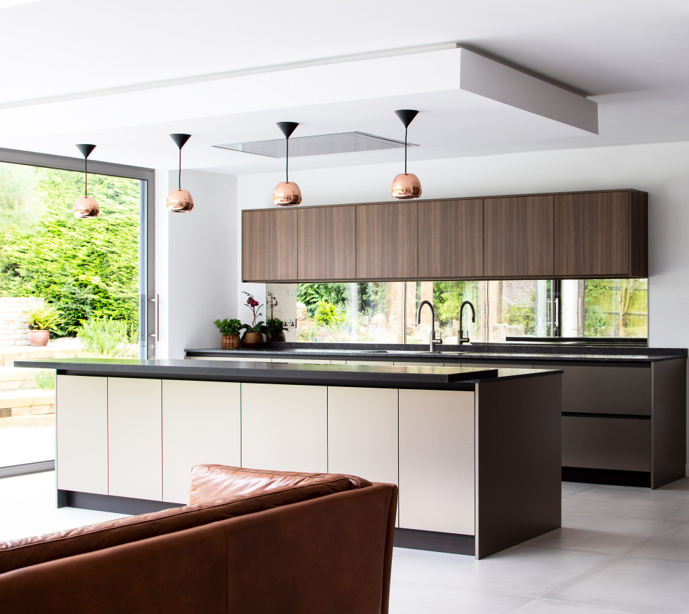 Zweizeilige Moderne Küche mit flächenbündigen Schrankfronten, dunklen Holzschränken, Rückwand-Fenster, Kücheninsel, grauem Boden und grauer Arbeitsplatte in Sonstige