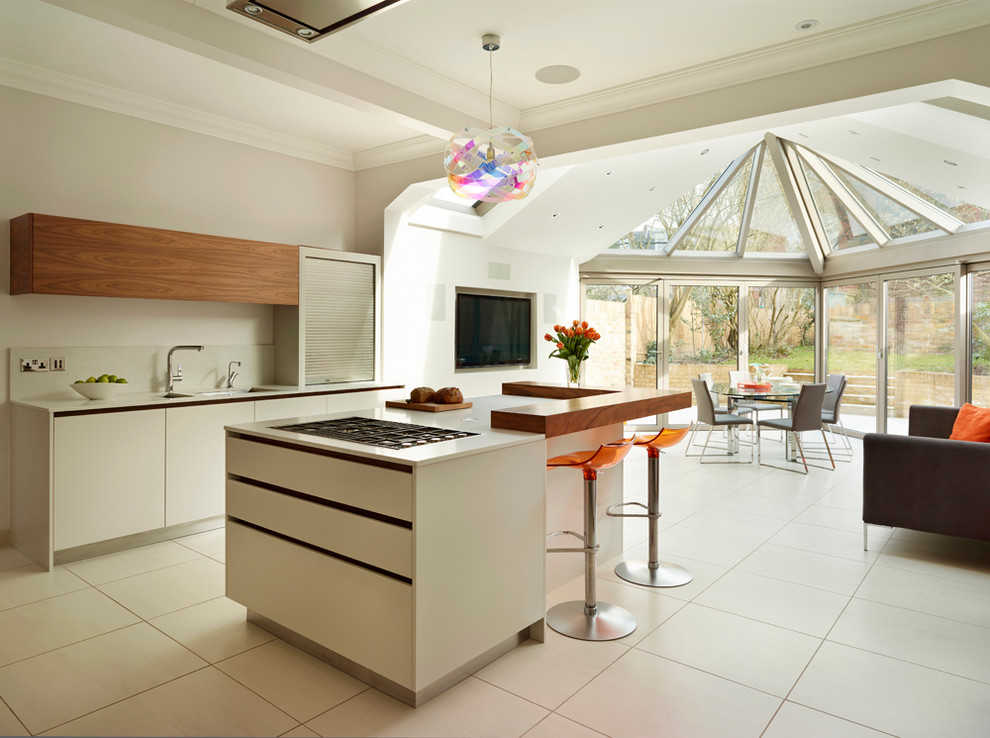 На фото: параллельная кухня-гостиная в современном стиле с врезной мойкой, плоскими фасадами, белыми фасадами, белым фартуком и островом с