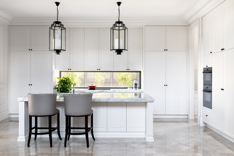 Inspiration för klassiska grått l-kök, med luckor med upphöjd panel, vita skåp, fönster som stänkskydd, rostfria vitvaror, en köksö och grått golv