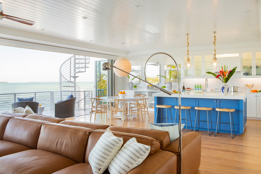 Immagine di una cucina costiera di medie dimensioni con lavello sottopiano, ante in stile shaker, ante blu, paraspruzzi bianco, pavimento in legno massello medio, pavimento marrone e top bianco