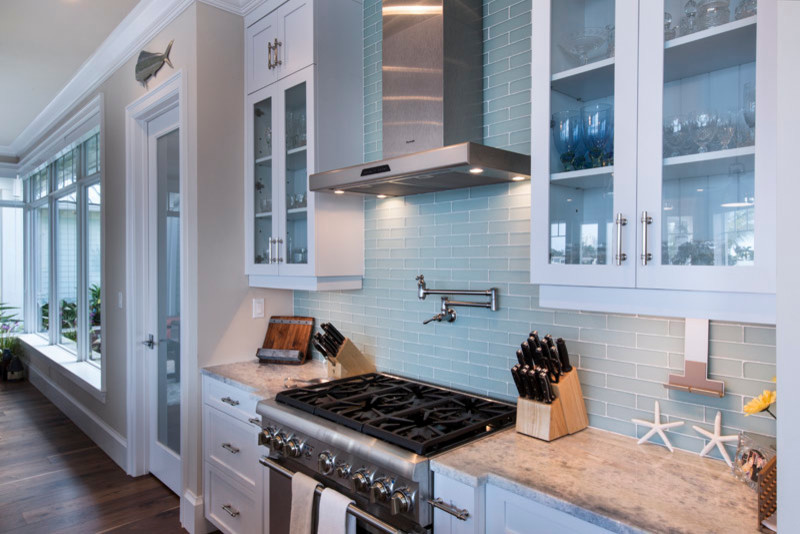 Geschlossene, Geräumige Küche in U-Form mit Granit-Arbeitsplatte und braunem Holzboden in Miami