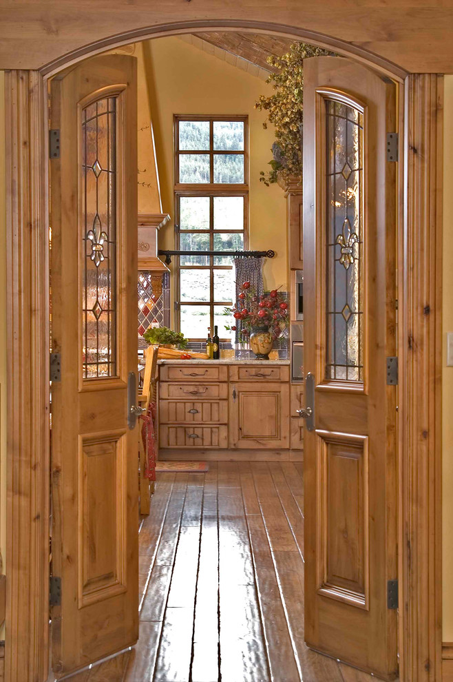 Große, Geschlossene Klassische Küche mit Landhausspüle, profilierten Schrankfronten, hellbraunen Holzschränken, Granit-Arbeitsplatte, bunter Rückwand, Rückwand aus Steinfliesen, Elektrogeräten mit Frontblende, hellem Holzboden und Kücheninsel in Denver