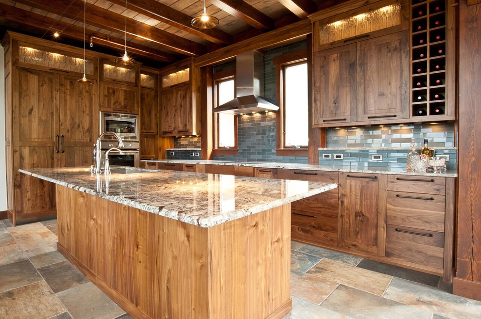 Bild på ett stort rustikt flerfärgad flerfärgat kök, med en undermonterad diskho, skåp i shakerstil, skåp i mellenmörkt trä, granitbänkskiva, blått stänkskydd, stänkskydd i glaskakel, rostfria vitvaror, skiffergolv, en köksö och flerfärgat golv