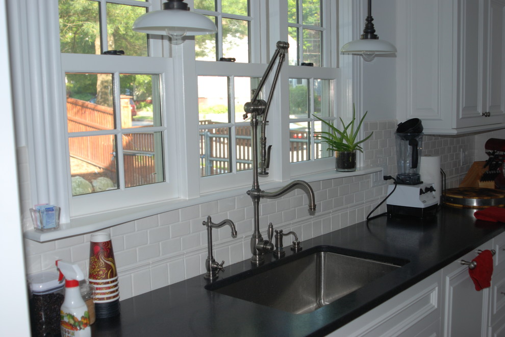 Esempio di una cucina classica con lavello sottopiano, ante con bugna sagomata, ante bianche e paraspruzzi bianco