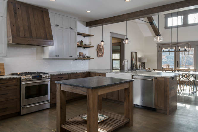 Bild på ett mellanstort amerikanskt kök, med en rustik diskho, skåp i shakerstil, grå skåp, granitbänkskiva, vitt stänkskydd, stänkskydd i tunnelbanekakel, rostfria vitvaror, mörkt trägolv, en köksö och brunt golv