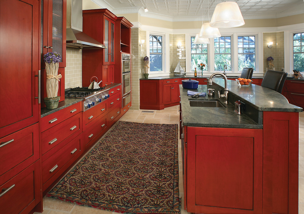 Inredning av ett klassiskt kök, med en undermonterad diskho, skåp i shakerstil, röda skåp, beige stänkskydd, stänkskydd i tunnelbanekakel och integrerade vitvaror