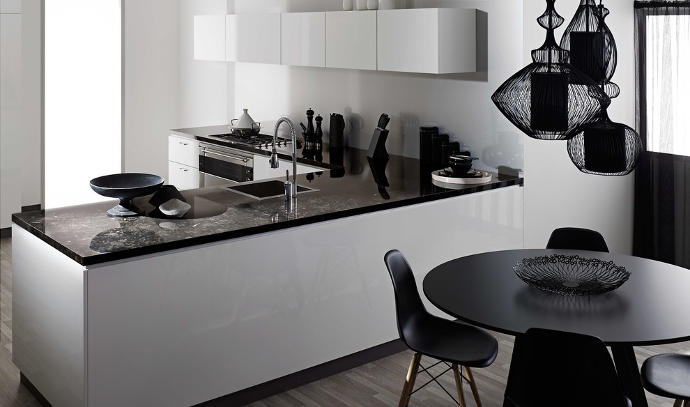 This is an example of a modern kitchen in Auckland with white cabinets, laminate countertops and stainless steel appliances.