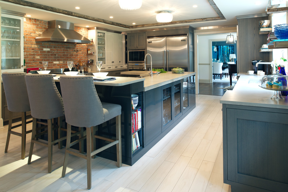 Modern inredning av ett mycket stort kök och matrum, med en undermonterad diskho, släta luckor, grå skåp, träbänkskiva, rostfria vitvaror, klinkergolv i porslin och en köksö