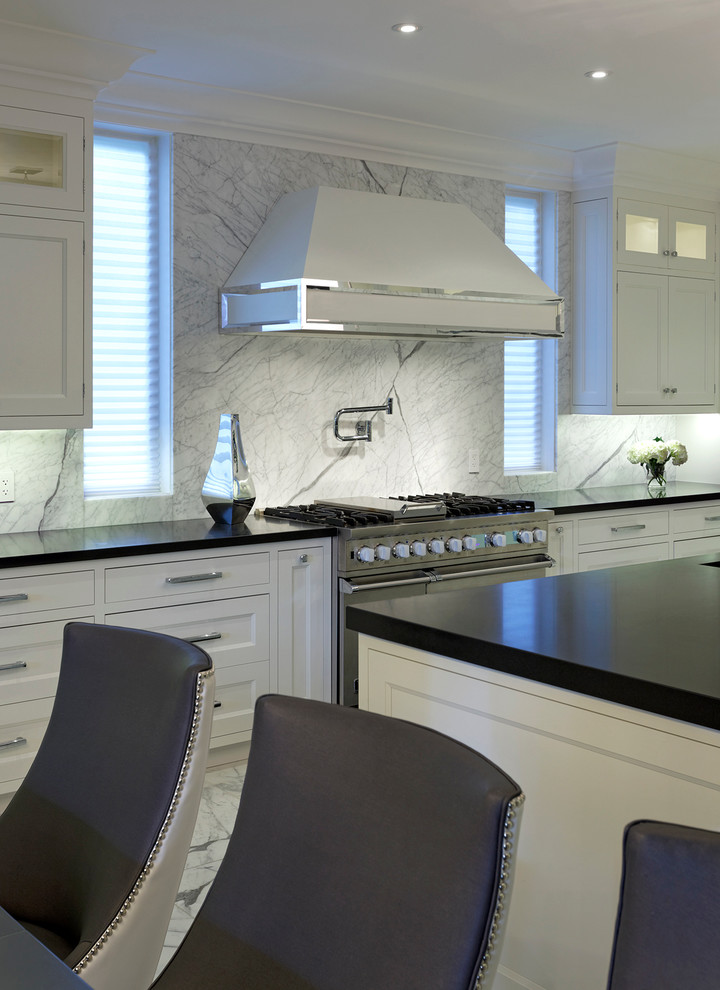 Photo of a large contemporary l-shaped kitchen/diner in Toronto with a submerged sink, recessed-panel cabinets, white cabinets, engineered stone countertops, grey splashback, integrated appliances, marble flooring and an island.