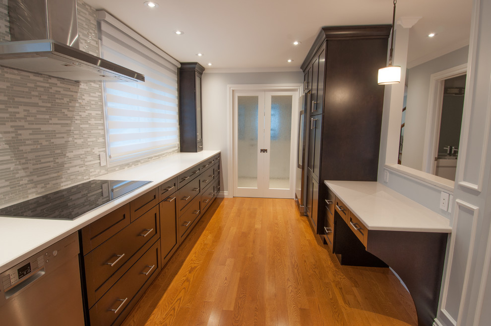 Enclosed kitchen - large transitional galley light wood floor enclosed kitchen idea in Toronto with a single-bowl sink, shaker cabinets, dark wood cabinets, quartzite countertops, beige backsplash, stone tile backsplash, stainless steel appliances and an island
