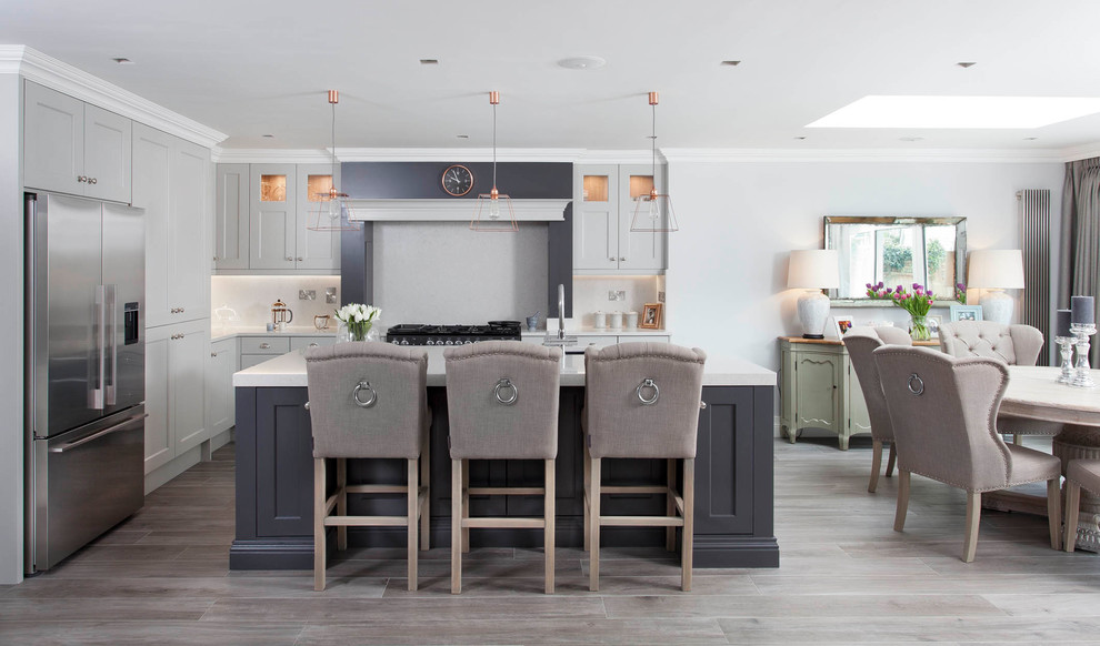 Inspiration for a large timeless l-shaped porcelain tile and brown floor open concept kitchen remodel in Other with an undermount sink, shaker cabinets, gray cabinets, quartzite countertops, gray backsplash, stone slab backsplash, stainless steel appliances and an island