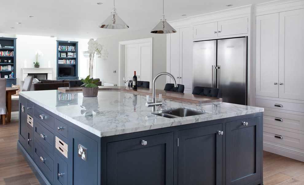Exempel på ett stort klassiskt kök, med en undermonterad diskho, skåp i shakerstil, grå skåp, marmorbänkskiva, grått stänkskydd, stänkskydd i marmor, rostfria vitvaror, mörkt trägolv, en köksö och brunt golv