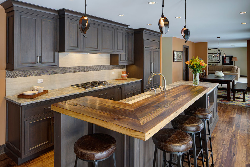 Inspiration for a large transitional l-shaped medium tone wood floor and brown floor eat-in kitchen remodel in Philadelphia with an undermount sink, beaded inset cabinets, distressed cabinets, wood countertops, beige backsplash, stone slab backsplash, stainless steel appliances and an island