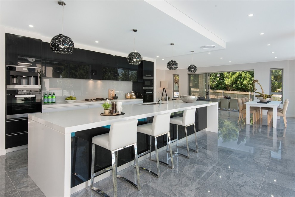 シドニーにあるコンテンポラリースタイルのおしゃれなアイランドキッチン (ドロップインシンク、白いキッチンパネル、白い調理設備、セラミックタイルの床、グレーの床) の写真