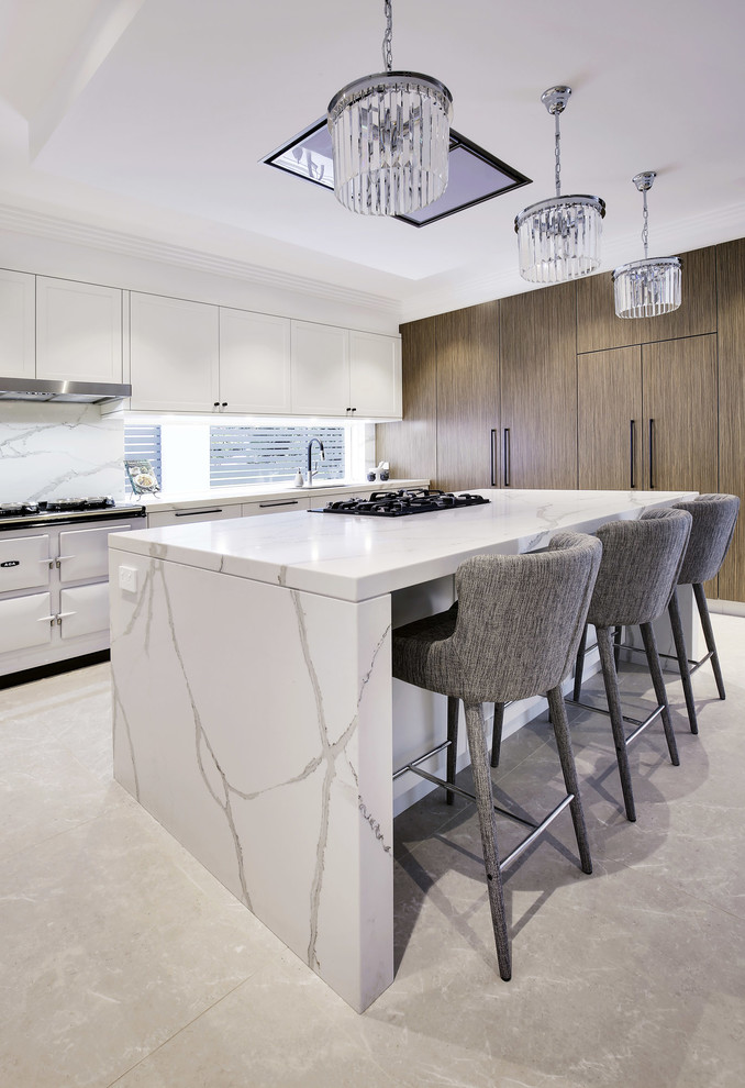 Photo of a large modern l-shaped kitchen/diner in Sydney with a double-bowl sink, shaker cabinets, white cabinets, engineered stone countertops, white splashback, stone tiled splashback, coloured appliances, limestone flooring, an island and beige floors.