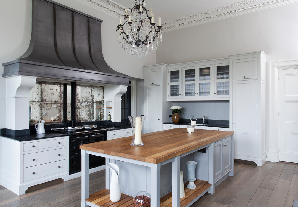 Foto de cocina comedor clásica con armarios con paneles empotrados y una isla