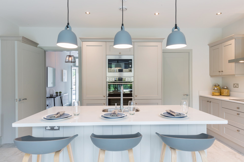 This is an example of a medium sized traditional open plan kitchen in Dublin with an island.