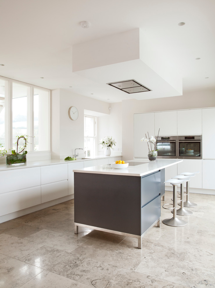 Moderne Küche mit weißen Schränken, Quarzit-Arbeitsplatte, Küchengeräten aus Edelstahl und Marmorboden in Sonstige