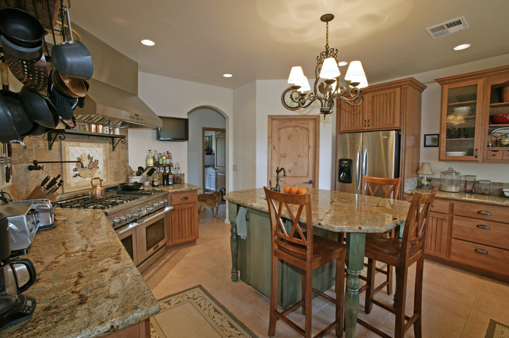 Example of a mountain style kitchen design in San Luis Obispo with glass-front cabinets, stainless steel appliances, light wood cabinets, multicolored backsplash, stone tile backsplash and granite countertops