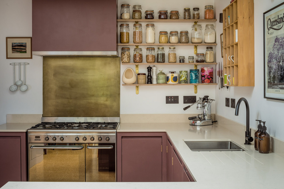 Modelo de cocina actual pequeña con fregadero encastrado, armarios con paneles lisos, puertas de armario violetas, encimera de cuarzo compacto, electrodomésticos negros y suelo de corcho