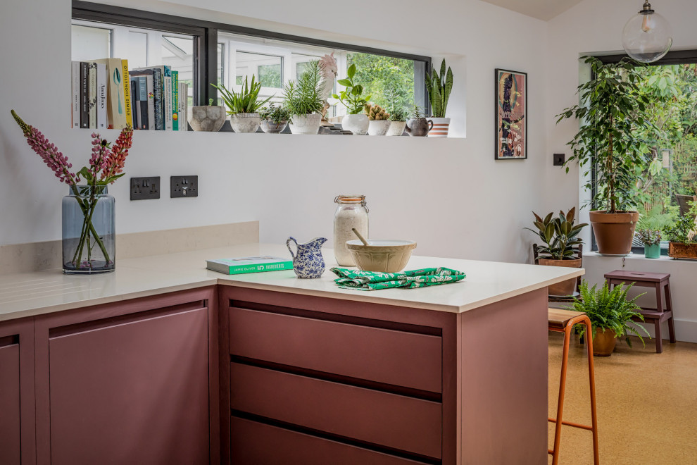 Immagine di una piccola cucina minimal con lavello da incasso, ante lisce, ante viola, top in quarzo composito, elettrodomestici neri e pavimento in sughero