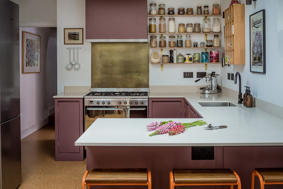 Inspiration for a small contemporary u-shaped kitchen/diner in West Midlands with a built-in sink, flat-panel cabinets, purple cabinets, engineered stone countertops, black appliances and cork flooring.