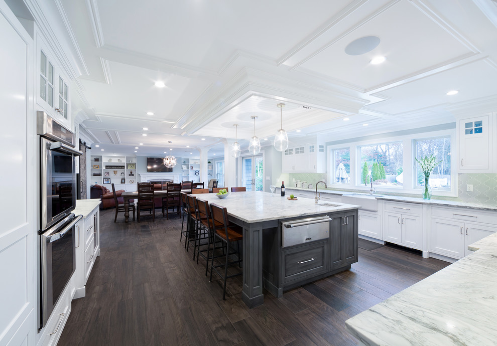 Large transitional u-shaped open concept kitchen photo with recessed-panel cabinets, white cabinets, marble countertops, green backsplash, glass tile backsplash, paneled appliances, an island and white countertops
