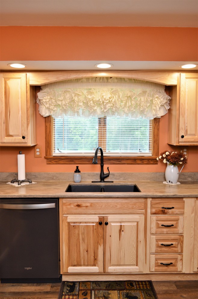 Rustik inredning av ett mellanstort brun brunt kök, med en undermonterad diskho, luckor med upphöjd panel, skåp i ljust trä, bänkskiva i koppar, rostfria vitvaror, laminatgolv, en halv köksö och brunt golv