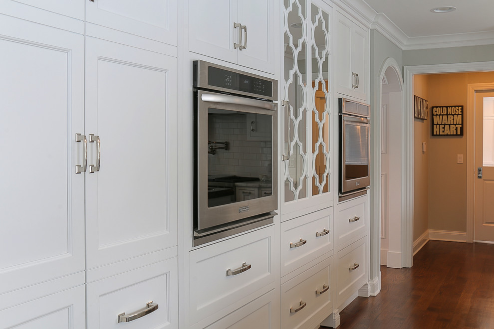 Example of a mid-sized transitional dark wood floor eat-in kitchen design in Chicago with an undermount sink, beaded inset cabinets, white cabinets, wood countertops, white backsplash, subway tile backsplash, paneled appliances and two islands