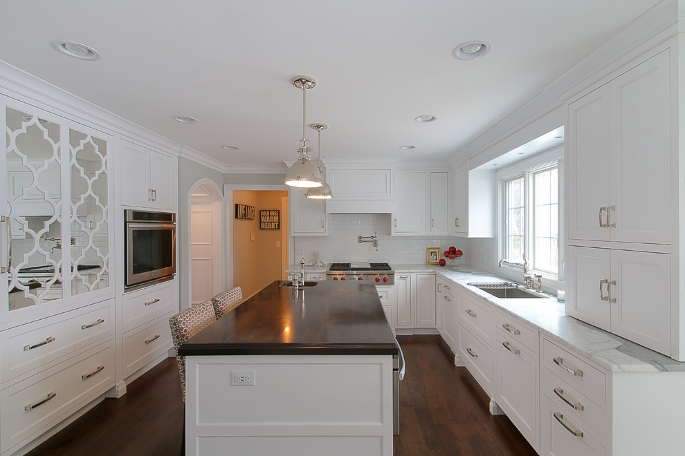 Mid-sized transitional dark wood floor eat-in kitchen photo in Chicago with an undermount sink, beaded inset cabinets, white cabinets, wood countertops, white backsplash, subway tile backsplash, paneled appliances and two islands
